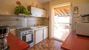 Eine Küche mit Herd, Spüle, Schränken und Kühlschrank.