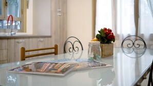 Une table à plateau en verre, un magazine, un petit pot contenant des objets décoratifs et un panier en osier.