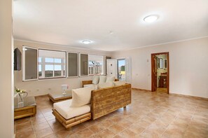 Quarto com cama, mesa de cabeceira, espelho e janela.