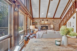 Cozy living room with exposed beams, brick fireplace, and comfortable seating area.
