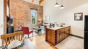 Una cocina con pared de ladrillo, vigas de madera y una isla grande con armarios.