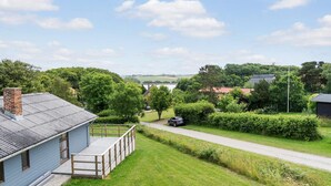 Ein Wohngebiet mit einem Haus, das eine Holzterrasse und ein Metalldach hat.