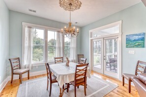 Un comedor con candelabro, ventanas amplias y vistas al exterior.