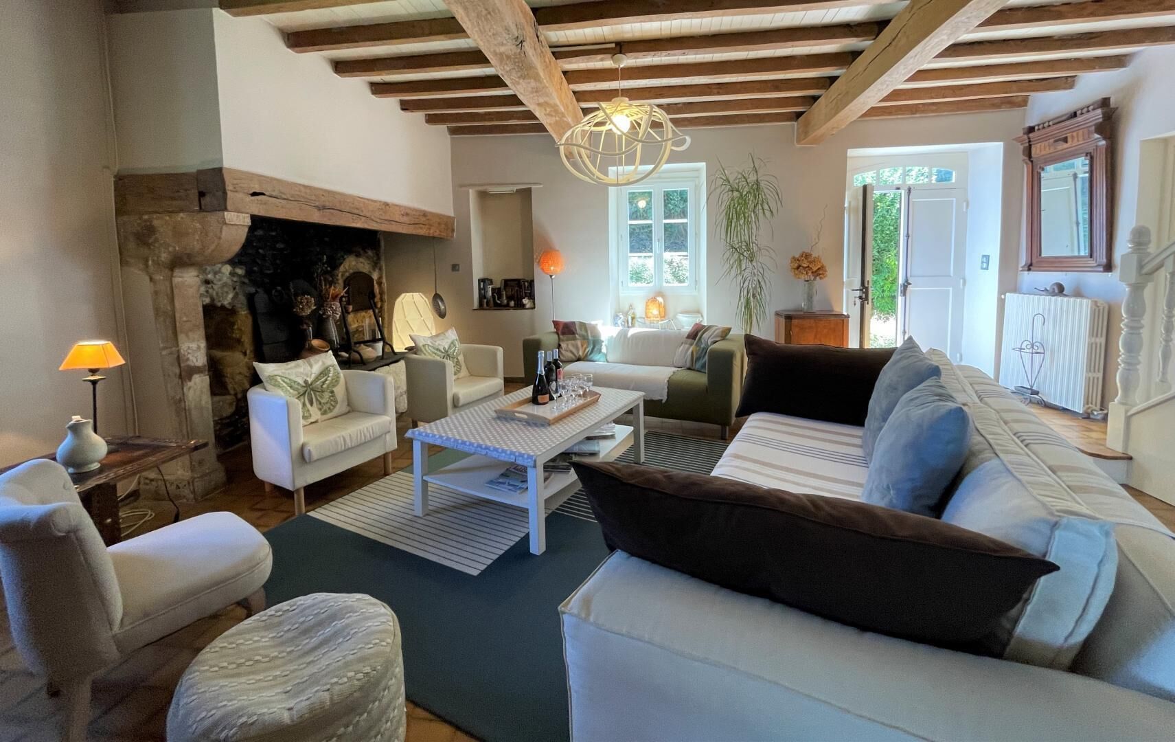 A cozy living room with a fireplace, comfortable seating, and a dining area.