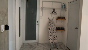 A hallway with a marble floor, a door, a hanging plant, and a shelf with items. - Isla Verde- Beach/Bar/Restaurants
Near Airport For Same Day Booking Message me
 (Carolina)