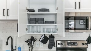 Een keuken met witte kasten, een roestvrijstalen oven en een magnetron.