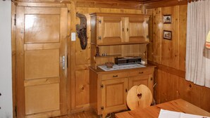 A wooden cabin interior with a wooden table, a radio, and a cabinet with a carved handle. - Ferienhaus - Wald am Arlberg (Wald am Arlberg)
