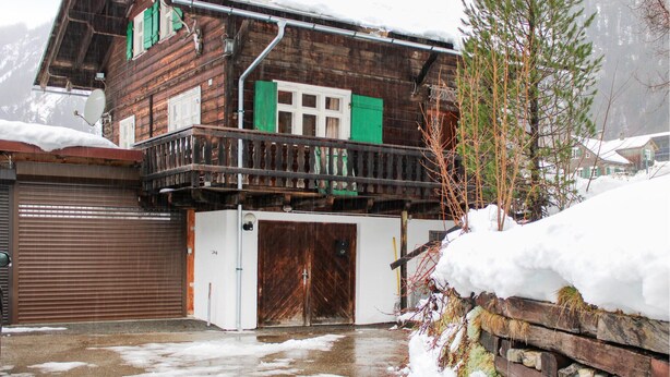 A wooden house with a balcony, a garage, and a snow-covered landscape. - Ferienhaus - Wald am Arlberg (Wald am Arlberg)