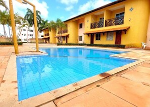 A swimming pool with tiled edges, surrounded by a tiled deck. - Menina do Vento (Salinópolis)