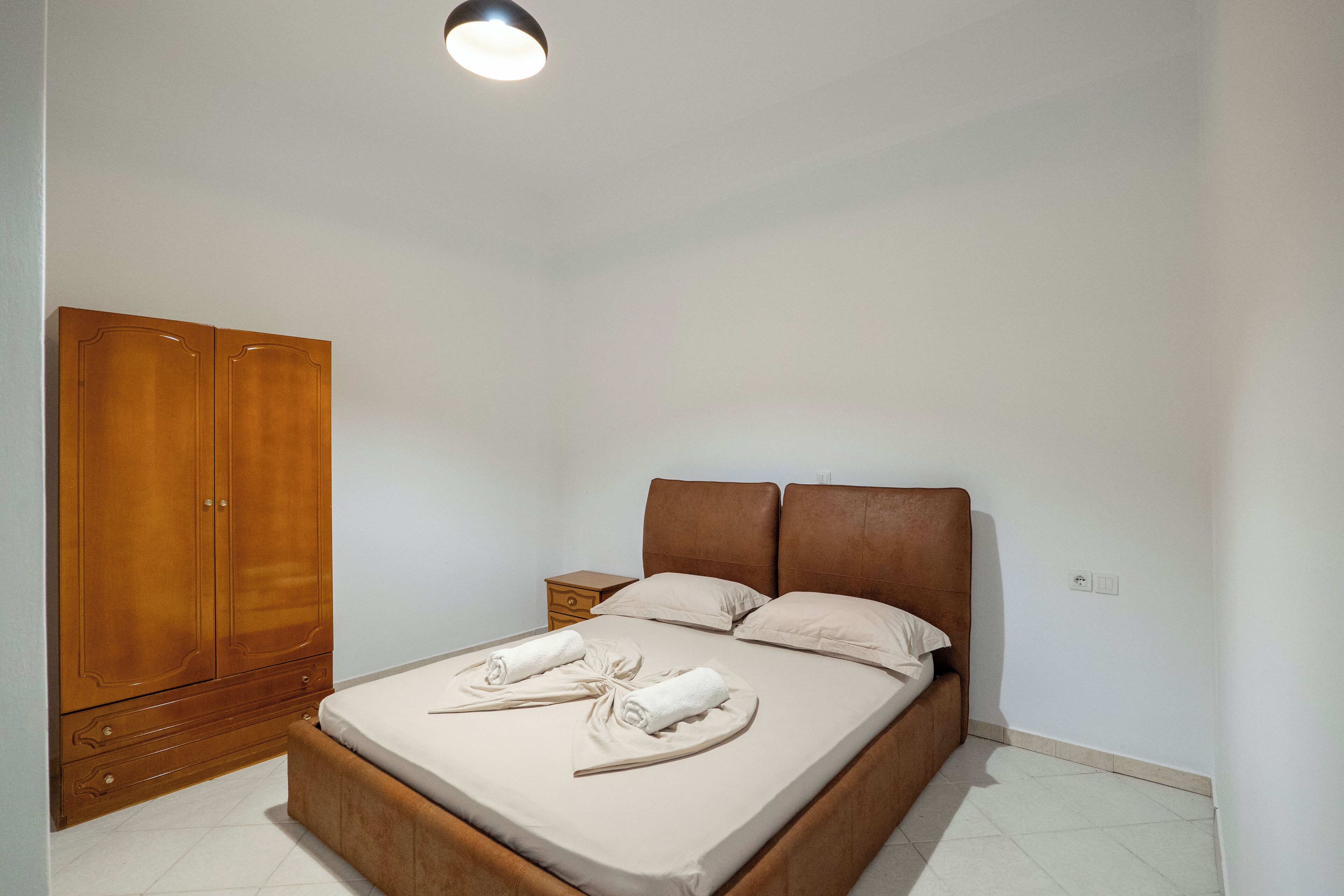 Une chambre à coucher avec un lit, une armoire et une table de chevet.
