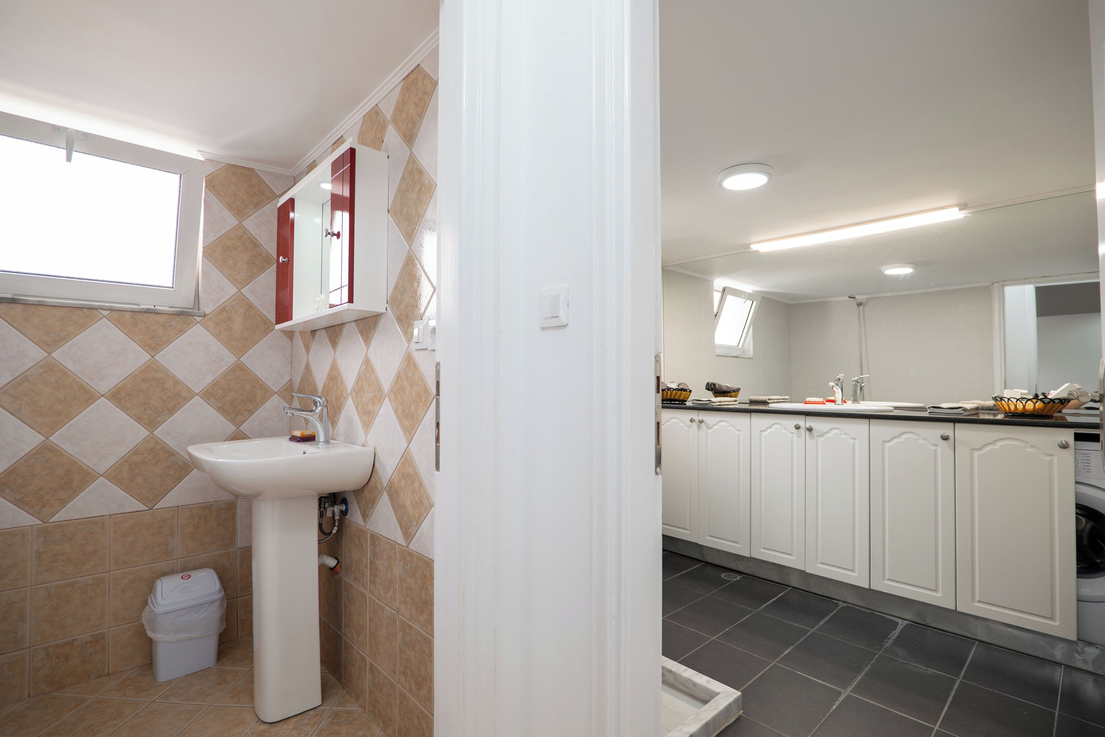 A modern bathroom with a sink, mirror, and tiled walls.