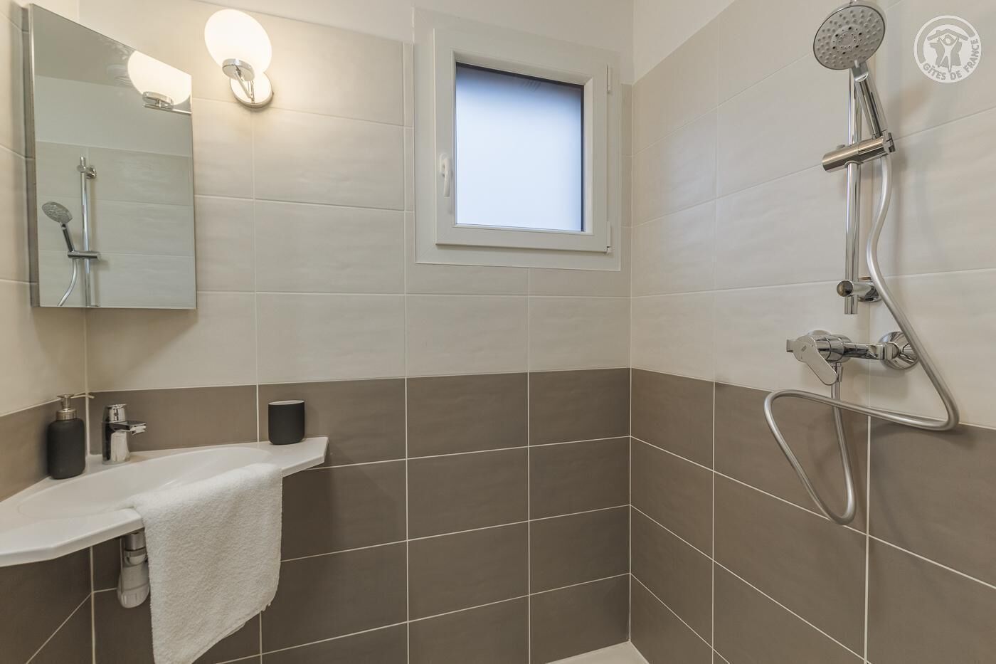 A modern bathroom with a shower, a sink, and a mirror.