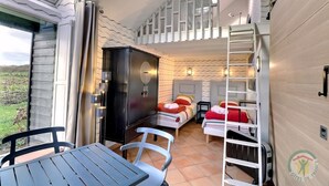 Una habitación con una cama, un escritorio, un armario y vistas al exterior.