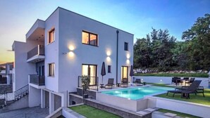 A modern two-story building with a swimming pool, outdoor seating, and a well-maintained lawn. - Beautiful home in Kostrena (Kostrena)