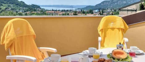 Mesa preparada para el desayuno con vista a un paisaje montañoso.