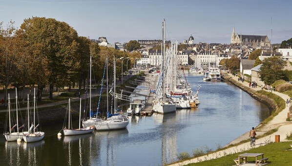 Stroll along the serene riverside promenade, taking in the views of sailboats and historic architecture.
