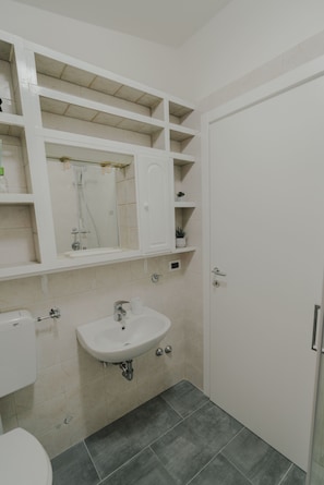 Een douche, een haardroger, een bidet, handdoeken