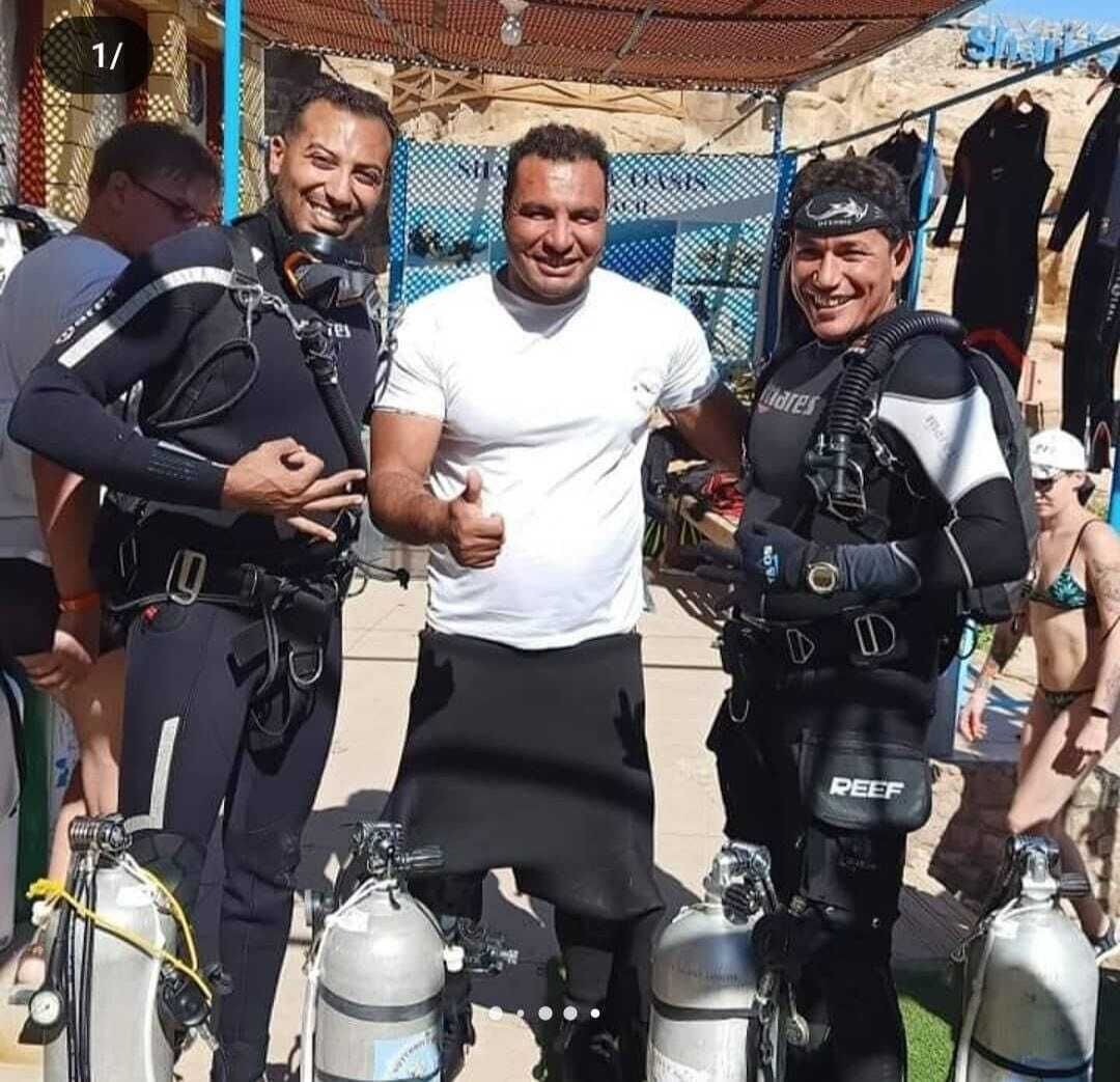 A group of divers with scuba gear and oxygen tanks.