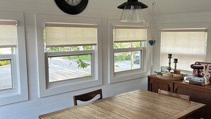 En matplats med ett träbord och stolar, en hängande lampa och en väggklocka.