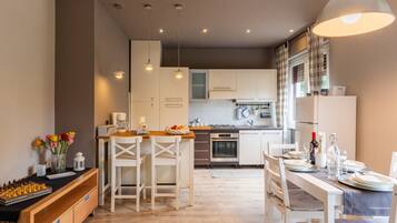 Een koelkast, een magnetron, een oven, kookgerei, borden en bestek