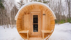 A wooden sauna with a circular design, a door, and two benches inside. - NEW Chalet 6 minutes from Sunday River! Hot tub, Sauna, Sleeps 12, Dog Friendly! (Bethel)