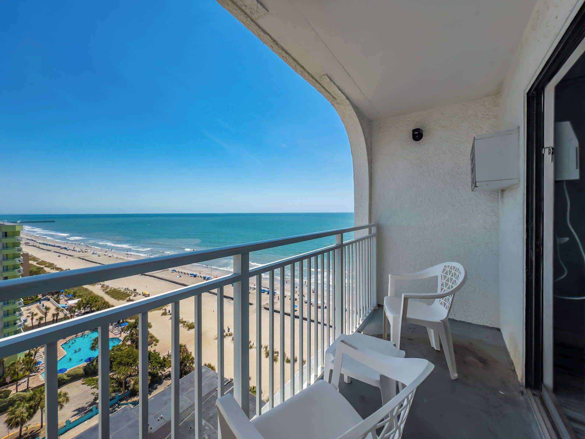 Un balcon avec vue sur la plage et une piscine.