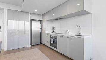 Een koelkast, een vaatwasser, een kinderstoel, eettafels