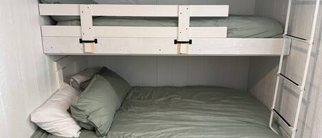 Ein Stockbett mit ausklappbarem Schreibtisch und einer Leiter.