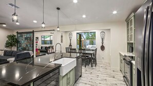 A modern kitchen with a central island, stainless steel appliances, and pendant lighting.