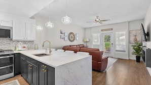 A modern kitchen with a marble island, black cabinets, and stainless steel appliances. - Located in Casa Del Mila Oro, ✨1st‑Floor Condo • 2 bedroom • Steps to the Pool ✨ (Osoyoos)