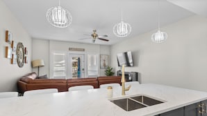 A modern kitchen with a marble countertop, a built-in sink, and a ceiling fan. - Located in Casa Del Mila Oro, ✨1st‑Floor Condo • 2 bedroom • Steps to the Pool ✨ (Osoyoos)