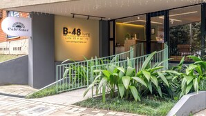 Un edificio moderno con un letrero que indica 'Cafe Soler' y 'B-48 living', señalando una unidad residencial.