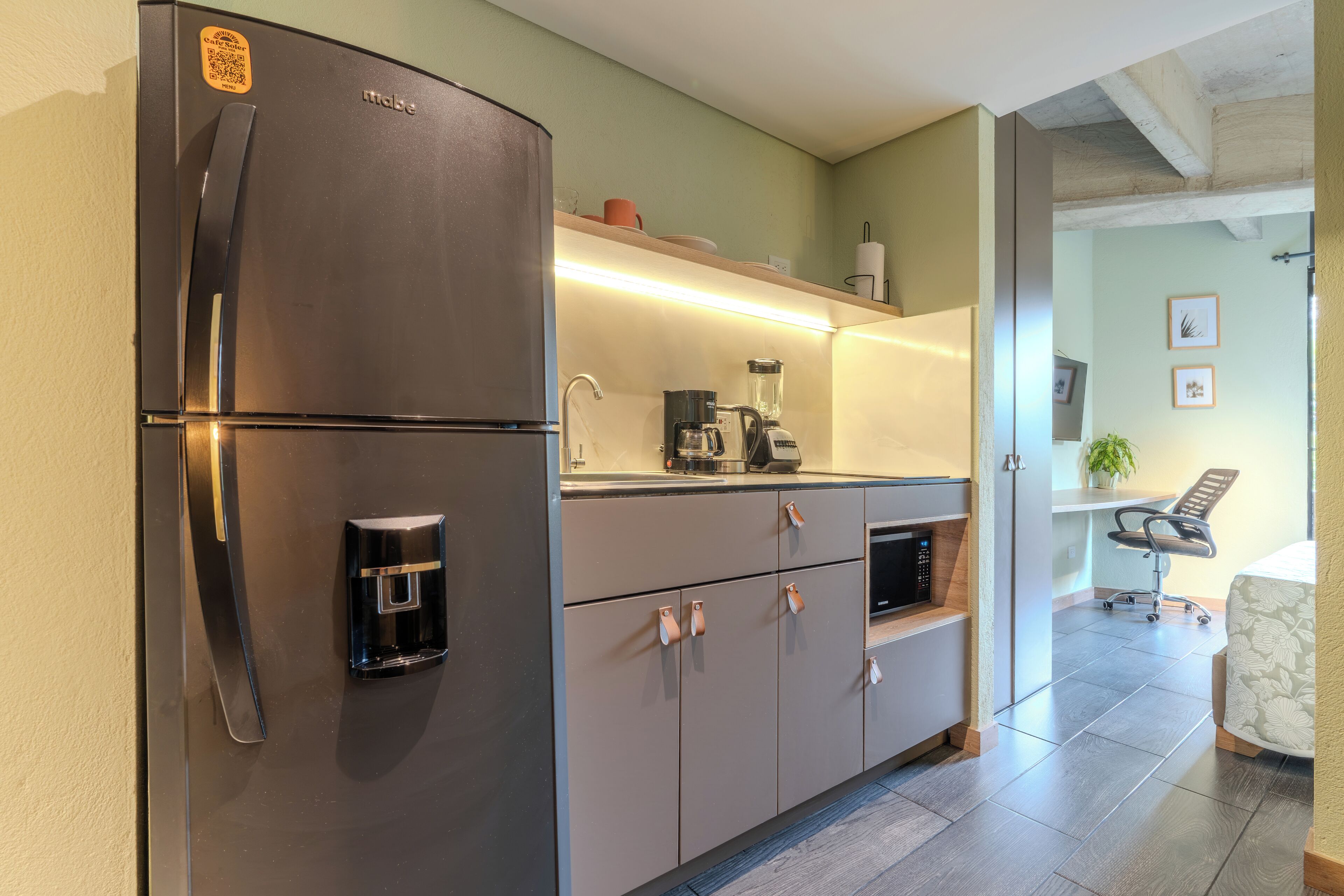 A modern kitchen with a built-in refrigerator, a coffee maker, and a sink.