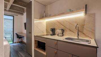 Eine moderne Küche mit integriertem Spülbecken, einer Kaffeemaschine und einer Mikrowelle.