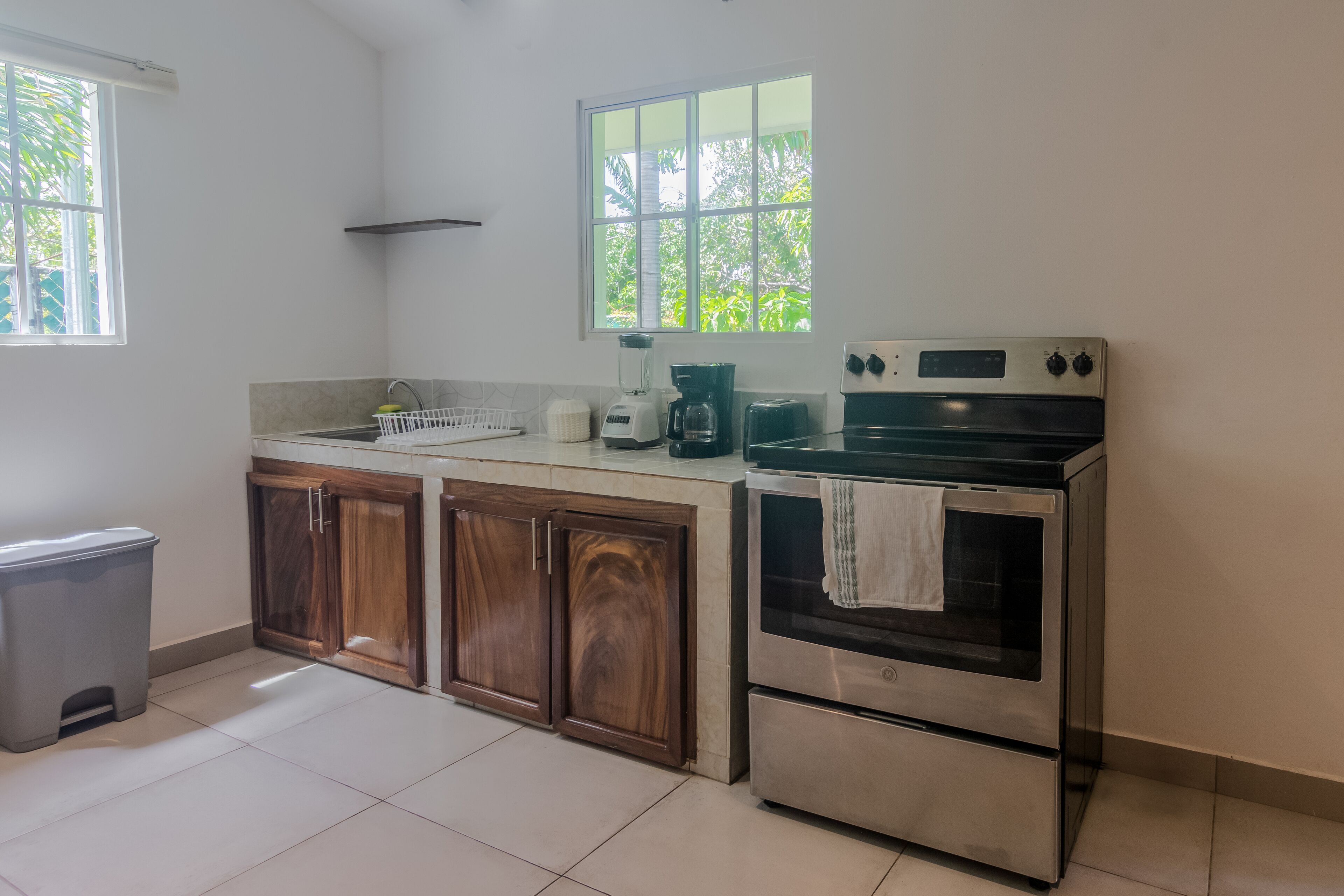 A kitchen with a stove, oven, and coffee maker.