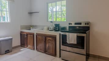 A kitchen with a stove, oven, and coffee maker.