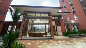 A modern building with a covered entrance, large windows, and a tiled walkway. - Shero Transpark Bekasi (Bekasi)