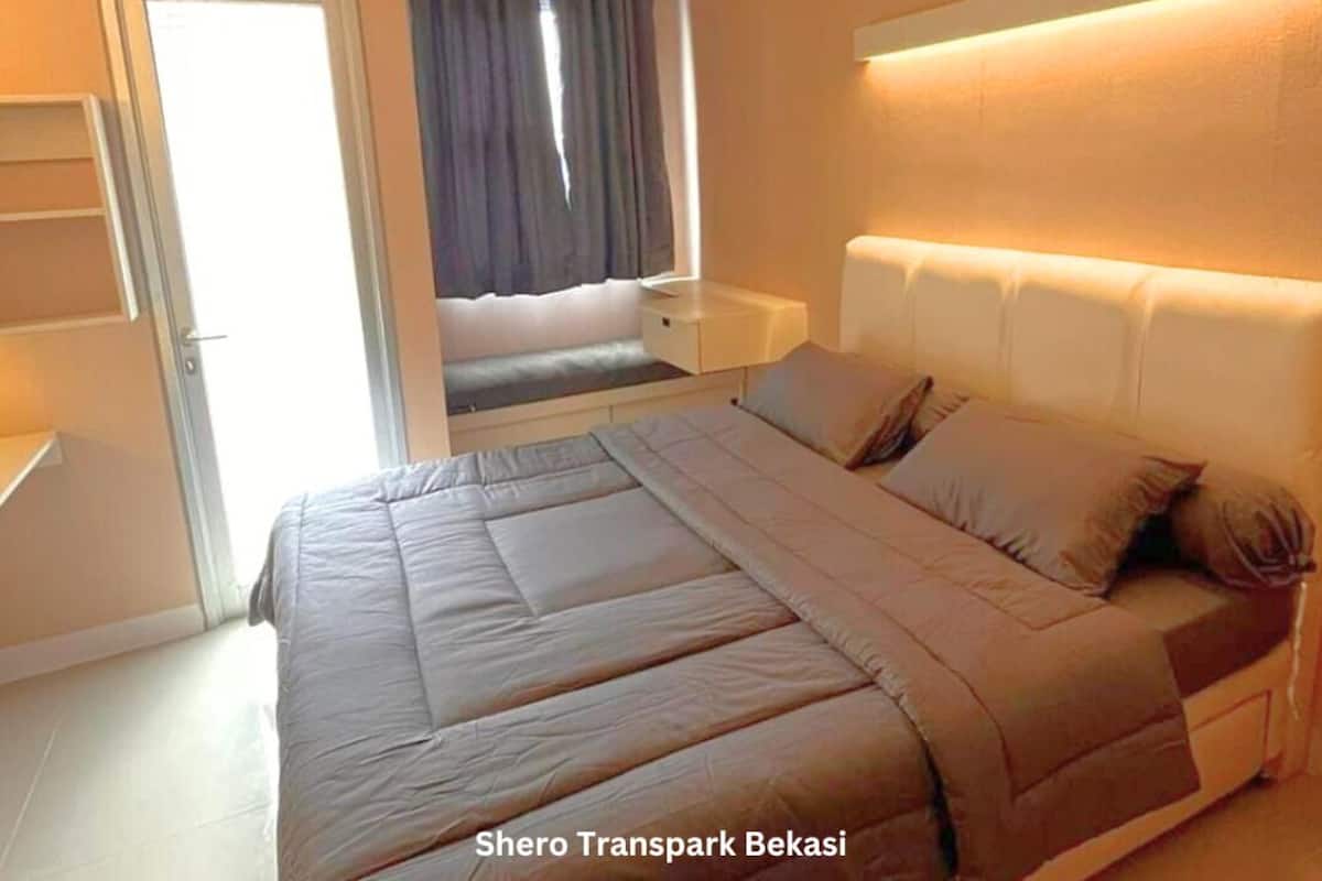 A bedroom with a bed, bedside table, and an air conditioning unit.