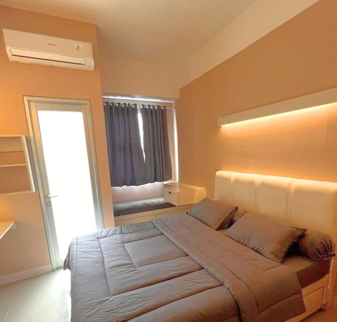 A bedroom with a bed, bedside table, and an air conditioning unit.