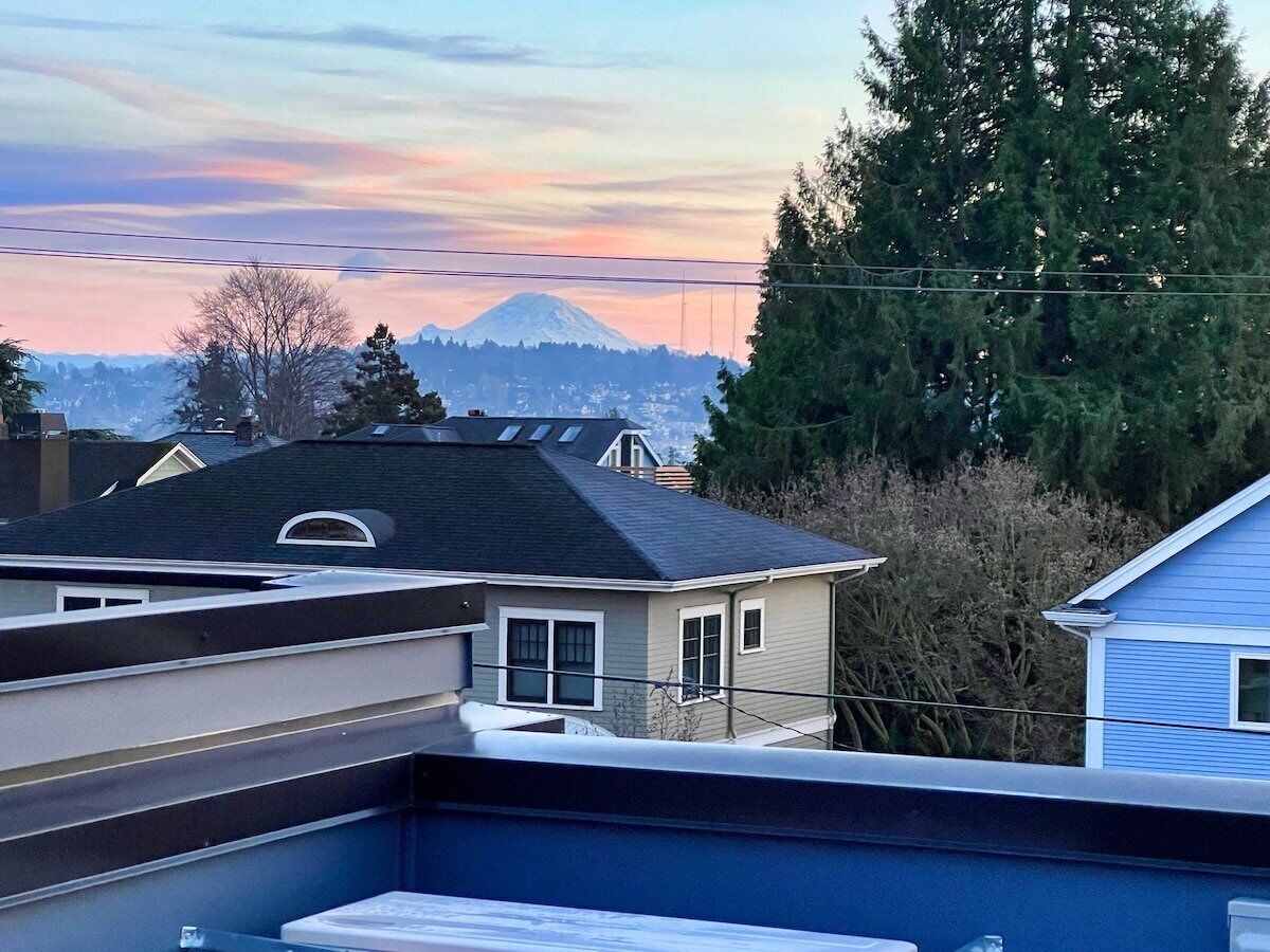 Un quartier résidentiel avec des maisons, une montagne en arrière-plan et un ciel dégagé.