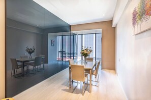 A modern interior with a dining area, large windows, and a glass partition.