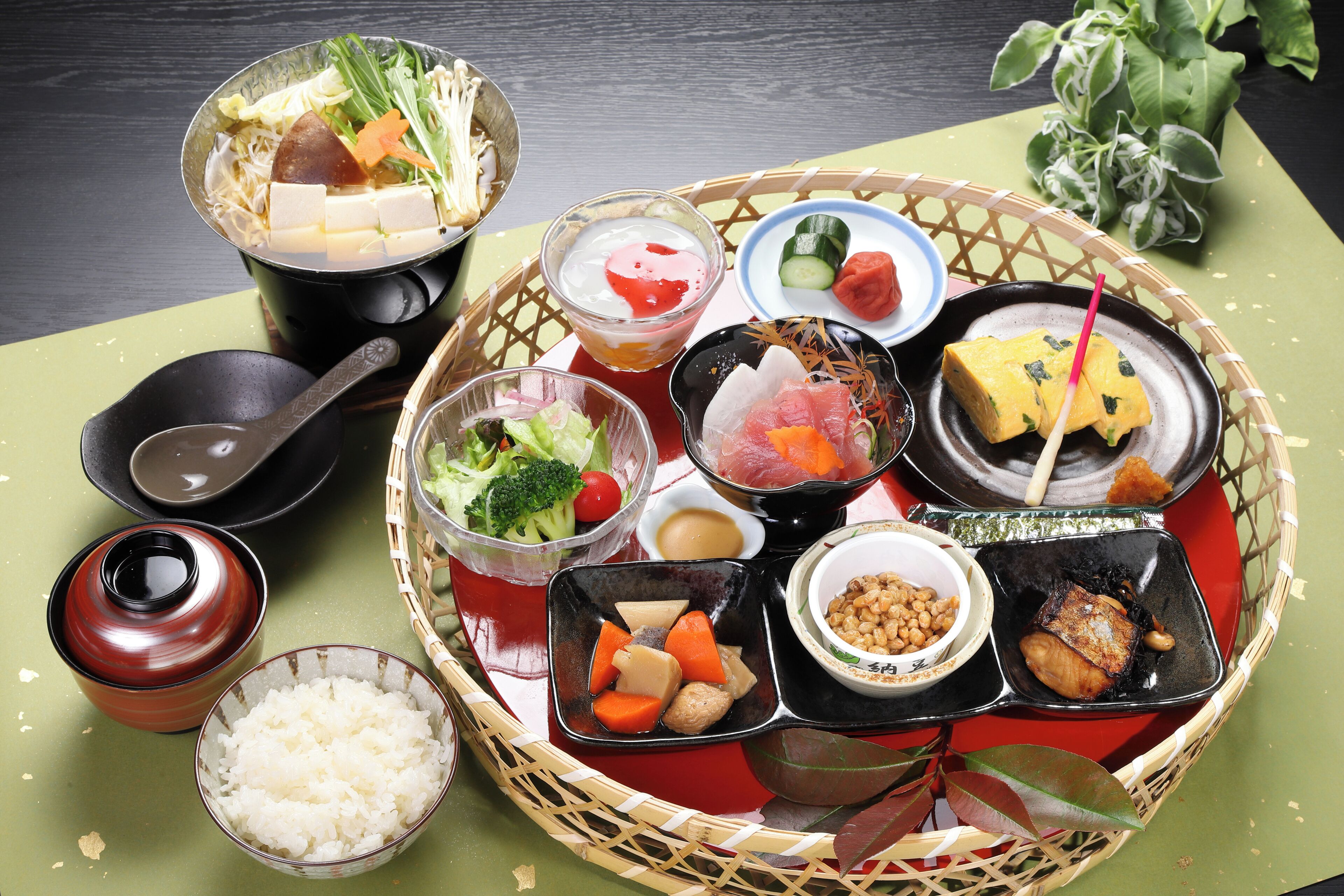 A traditional Japanese meal with various dishes and side items on a table.