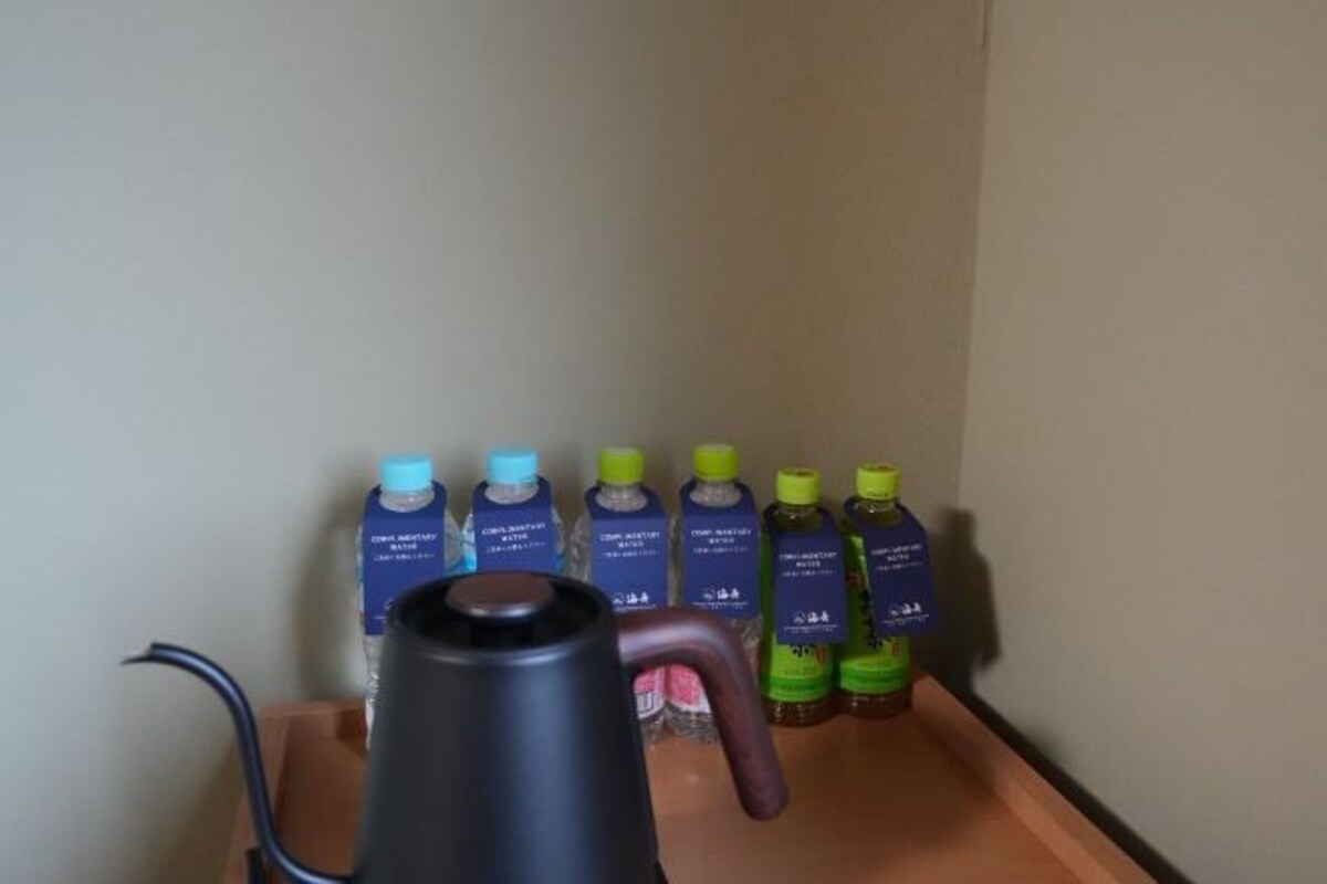 Una tetera y botellas de agua sobre una bandeja.