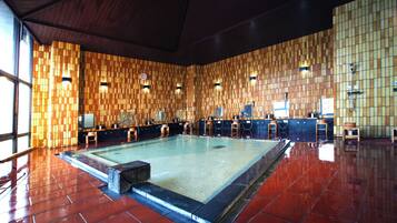 Una piscina con suelo y paredes de baldosas, rodeada de paneles de madera.