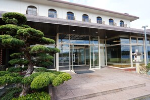 A building with a glass entrance, a large tree, and a statue in front. - KaigakuOsen Resort Shirahama (Shirahama)