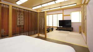 Perinteinen japanilaistyylinen huone, jossa on tatamimatto, sänky, televisio ja liukuvat ovet.