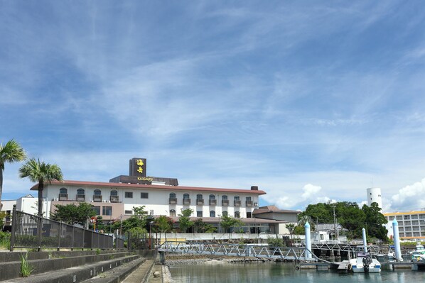 A waterfront building with a red roof, multiple balconies, and a clock tower. - KaigakuOsen Resort Shirahama (Shirahama)