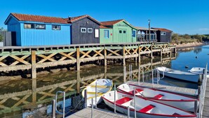 Un muelle de madera con casas de madera coloridas y barcos amarrados al final.