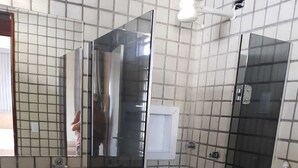 A bathroom with a glass shower enclosure, a toilet, and a sink with a mirror above it. - Casa Amarela Aeroclube (Aeroclube João Pessoa)