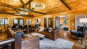 A log cabin interior with a living area, dining space, and kitchen.